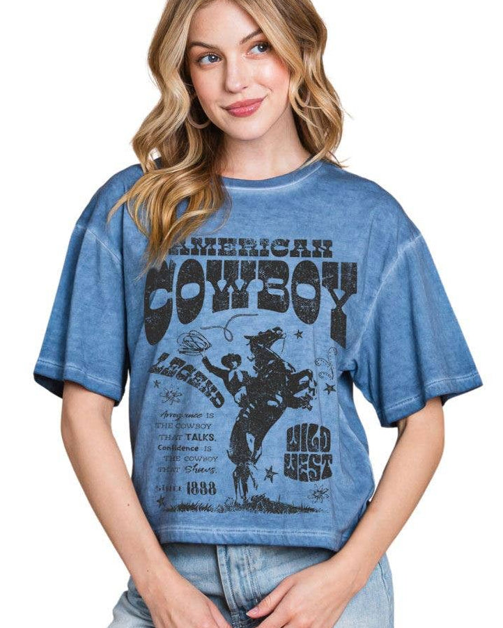 Woman wearing a blue graphic t-shirt with 'American Cowboy' design on a white background