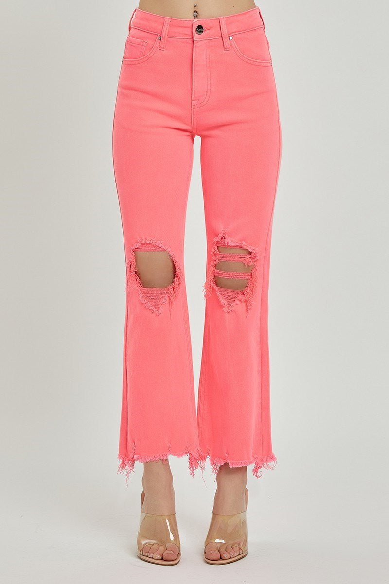 Pink jeans with distressed details on a gray background - coral cropped distressed jeans