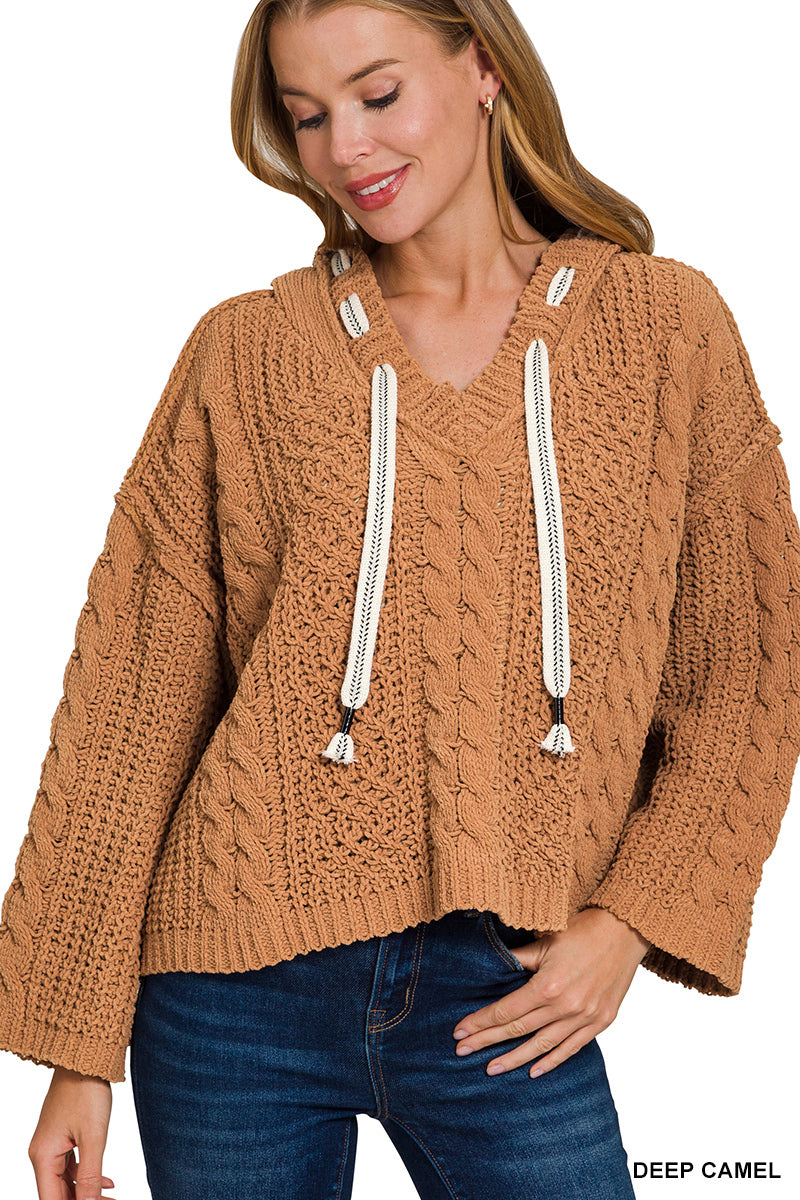 Woman wearing a brown knitted sweater with drawstrings on a white background